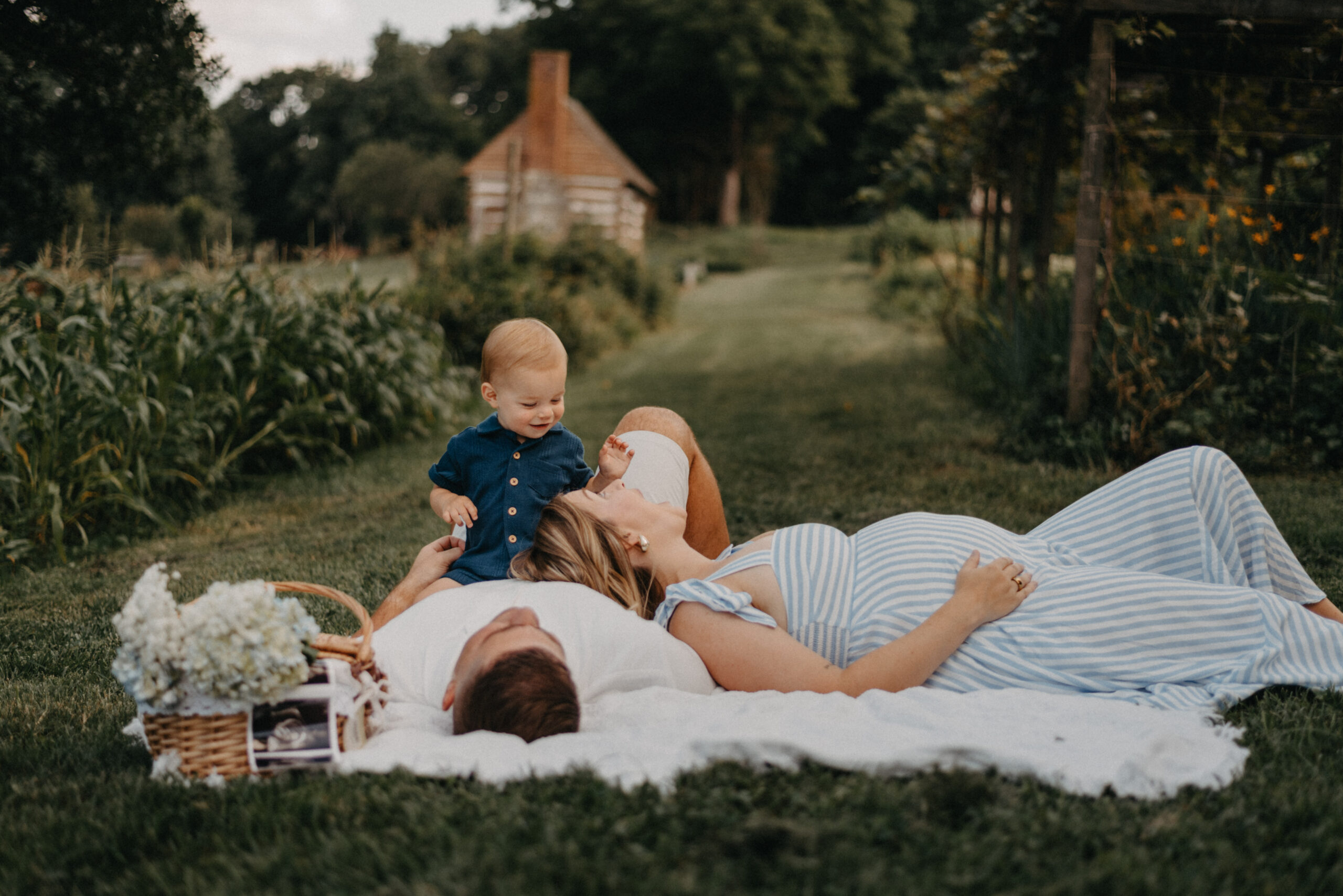 Family lying in grass with flowers and a toddler